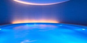Bassin de flottaison lumineux dans un centre de flottaison avec éclairage bleu et ambiance zen